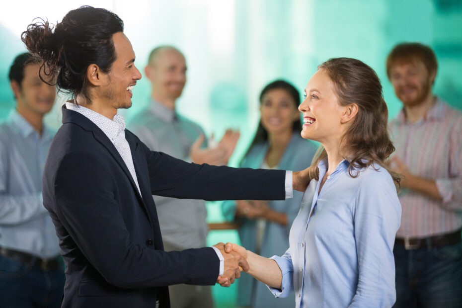 Man und Frau im Businesskontext, reichen sich die Hand